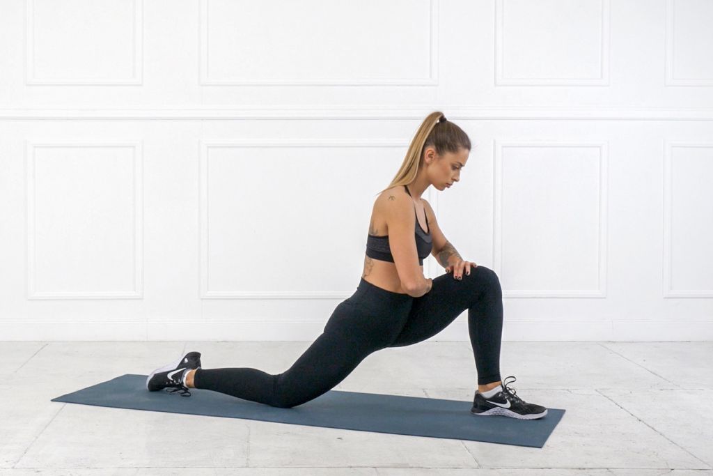 runner doing a hip flexor post run stretch on a yoga mat