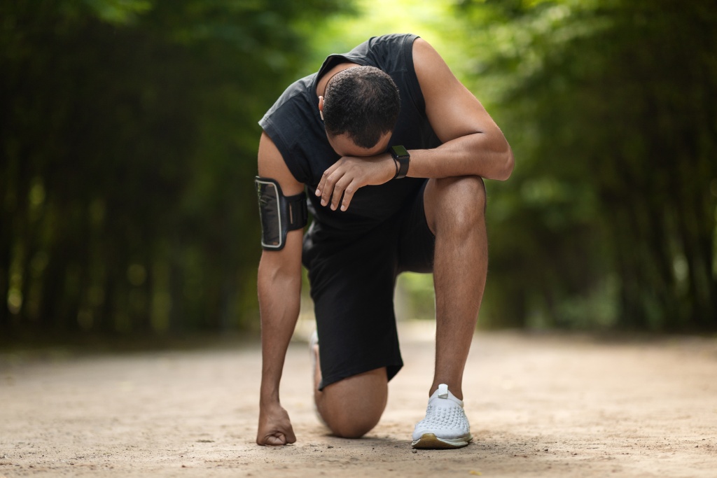 exhausted runner down on one knee